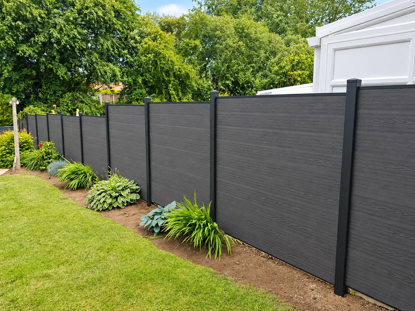 Dark horizontal composite-style panels and pale posts in a garden setting