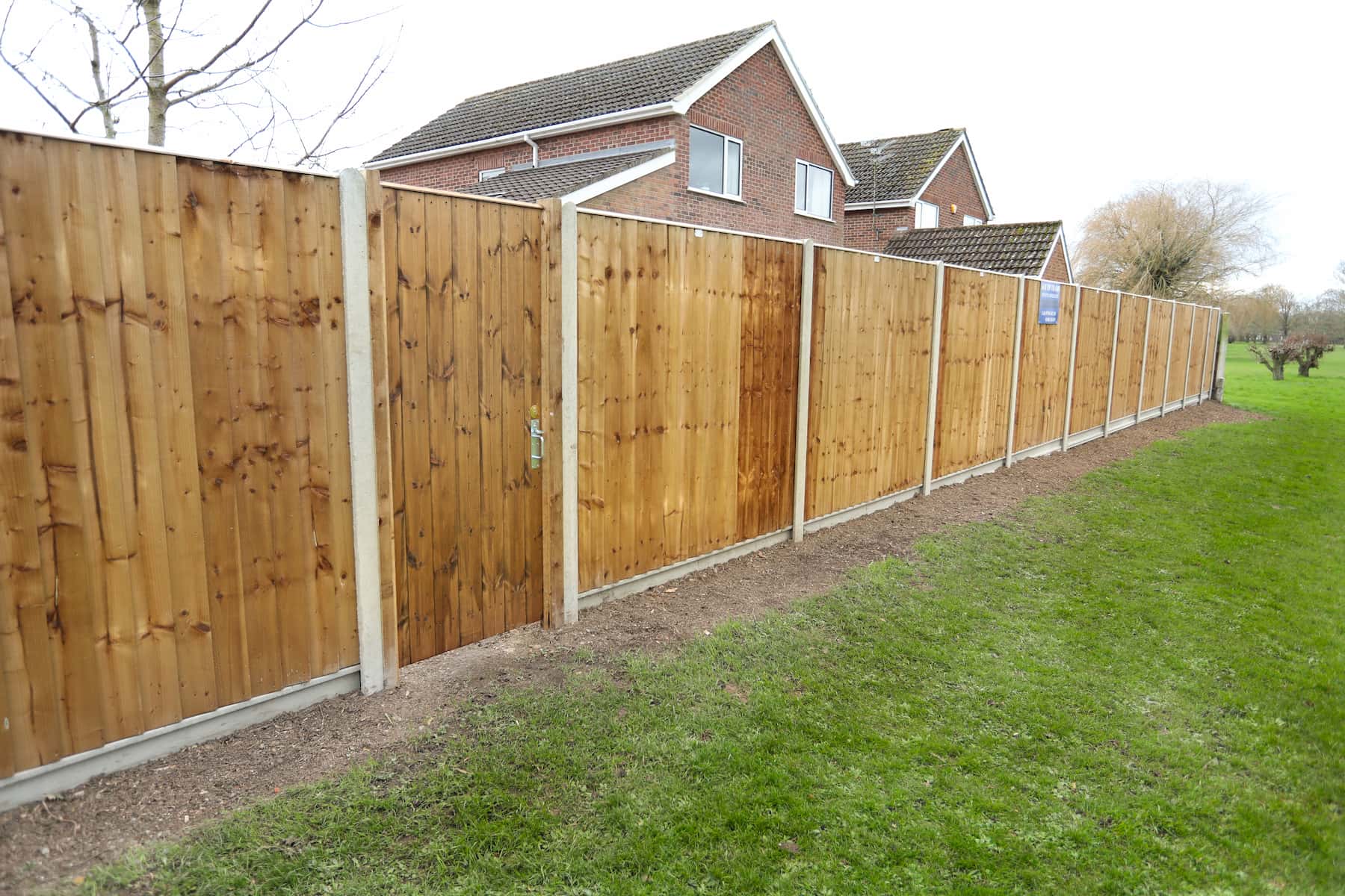 Supplied finish reference showing timber fence panels and posts beside a garden
